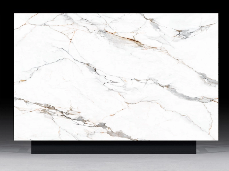 High-definition architectural surface panel featuring the bold grey brecciated veins and bronze filaments of Calacatta Vagli marble on a white background.